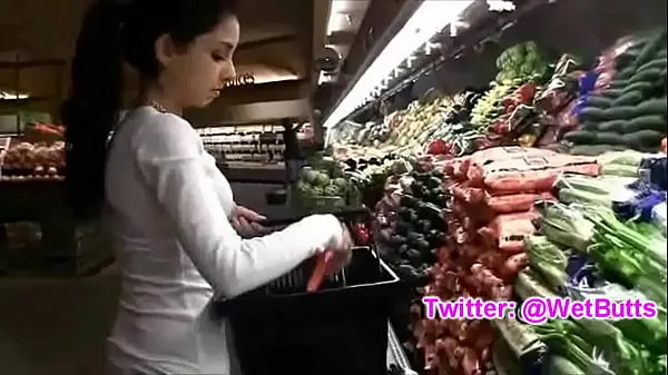 Regardez jeune gars jouant avec une carotte sur le marché clips chauds